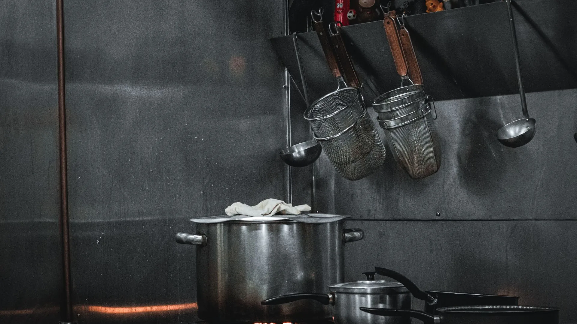 Polished stainless-steel commercial kitchen with professional range lines and prep stations